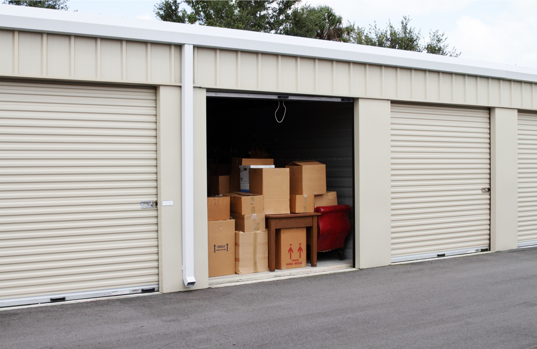 Storage unit door open filled with moving boxes.
